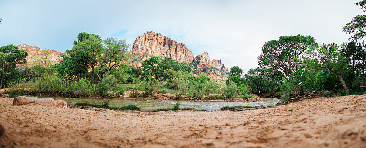 Riverbank with large mountains in background