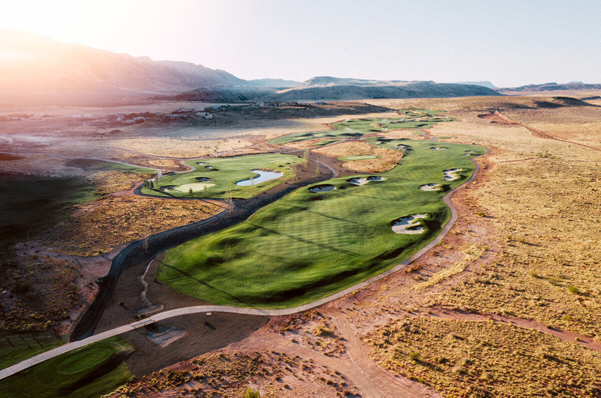 Aerial view of desert golf course with lens flare at sunrise