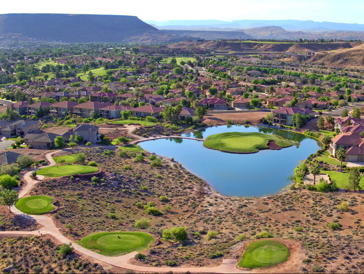 Aerial view of desert golf course with lava rocks and pond