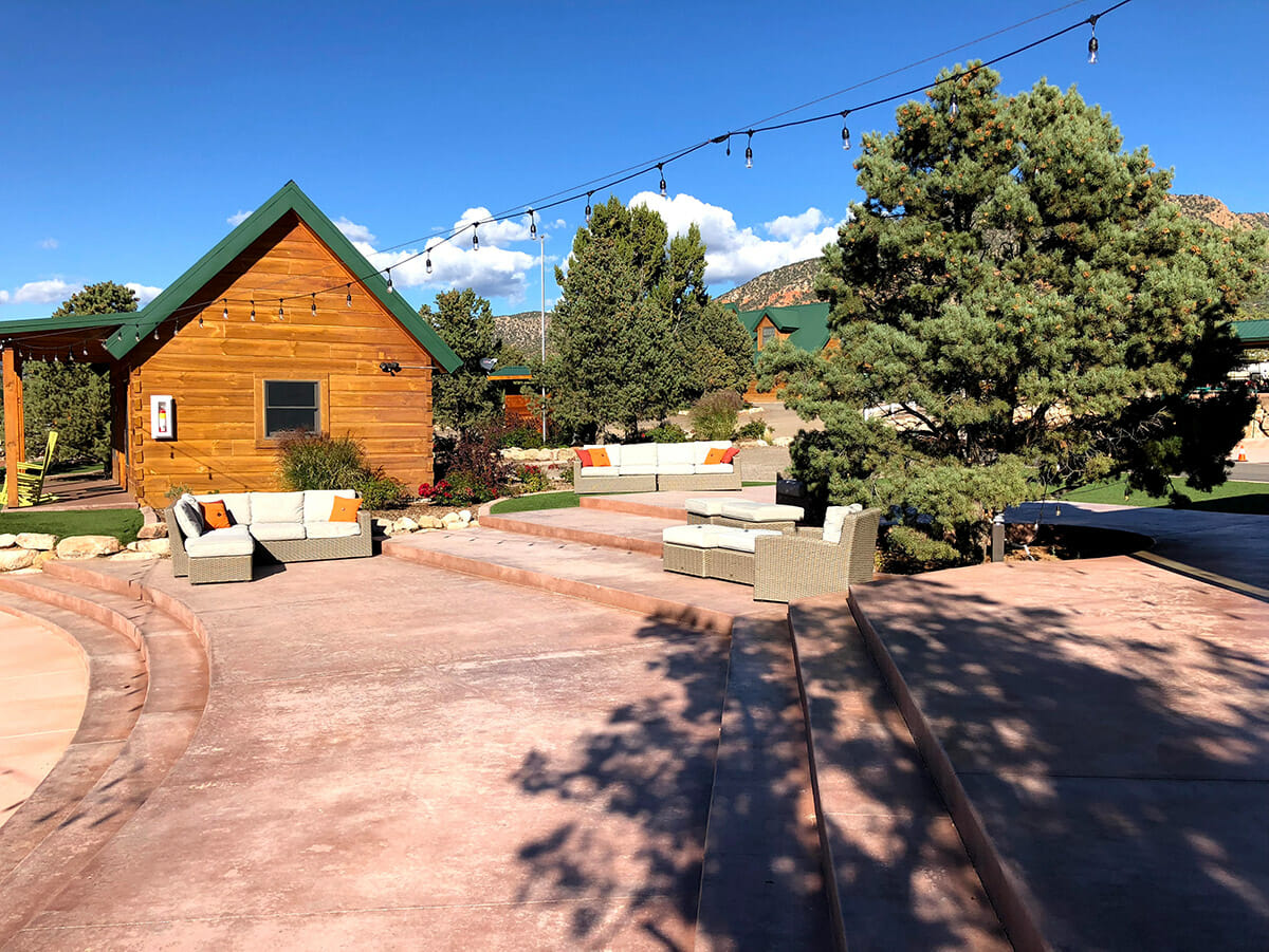 Outdoor seating area with cabin and blue skies