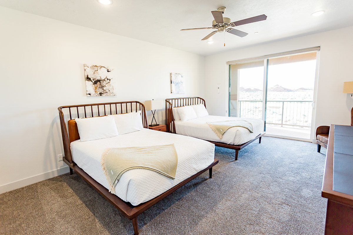 Two queen beds with wooden frames in hotel room