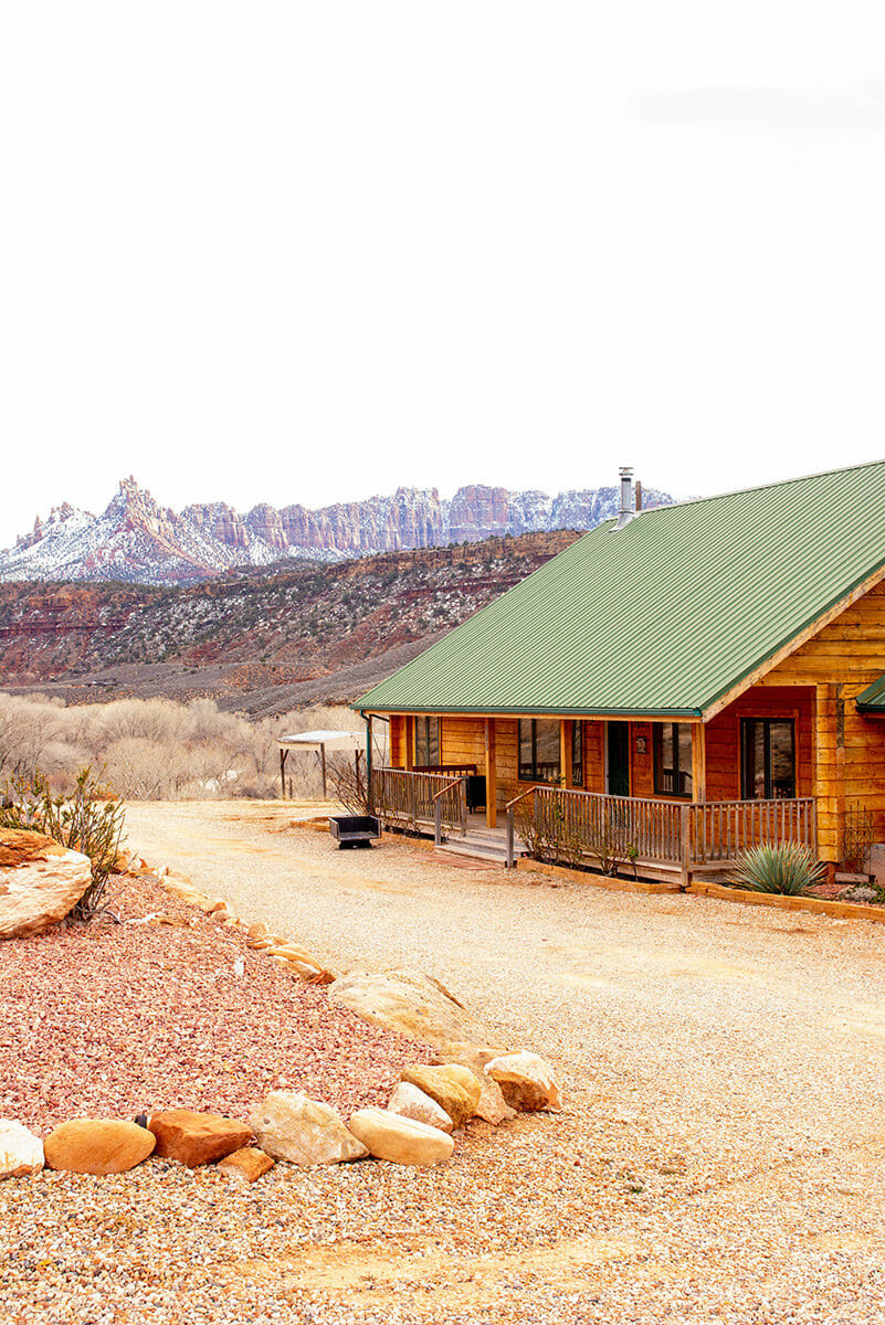 View of cabin with snow-covered mountains in the background