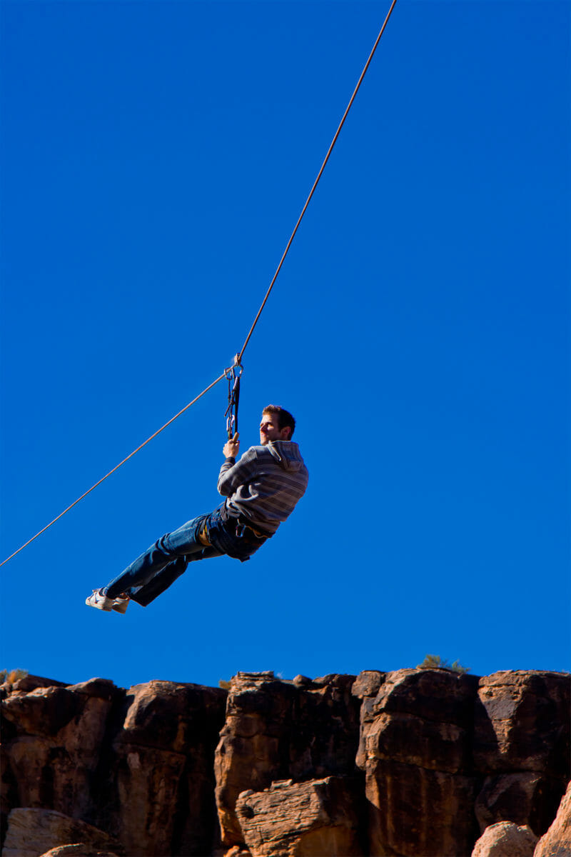 Ziplining man with a blue sky